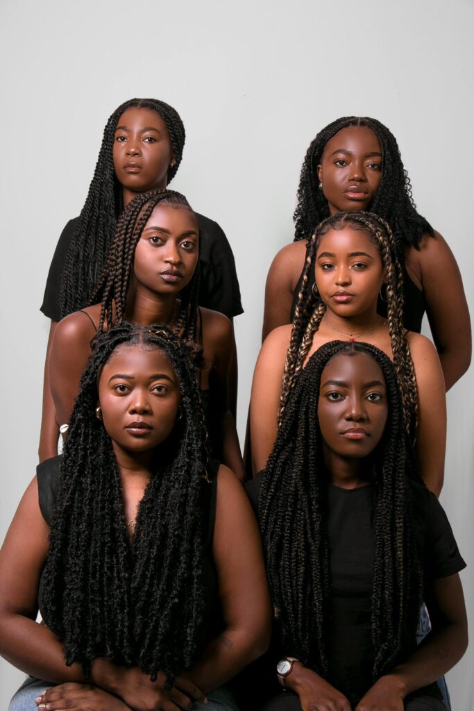 Elegant portrait of six African women showcasing beauty and unity with braided hairstyles.